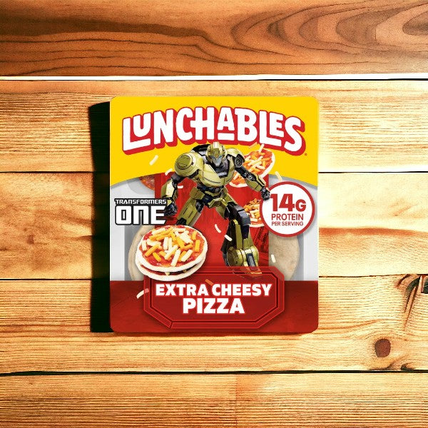 A package of Lunchables Extra Cheesy Pizza, 4.2 oz., from a 10-pack bundle, with 14g protein per serving, features a Transformers One character on the front. The convenient packaging is placed on a wooden surface.