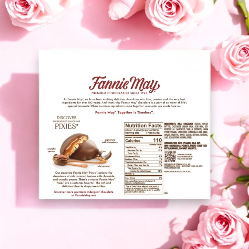 A Fannie May Chocolates Pixies box features detailed nutrition facts and an enticing description, set amid pink roses on a pink background. Relish the indulgent milk chocolate and buttery caramel that create these irresistible treats.