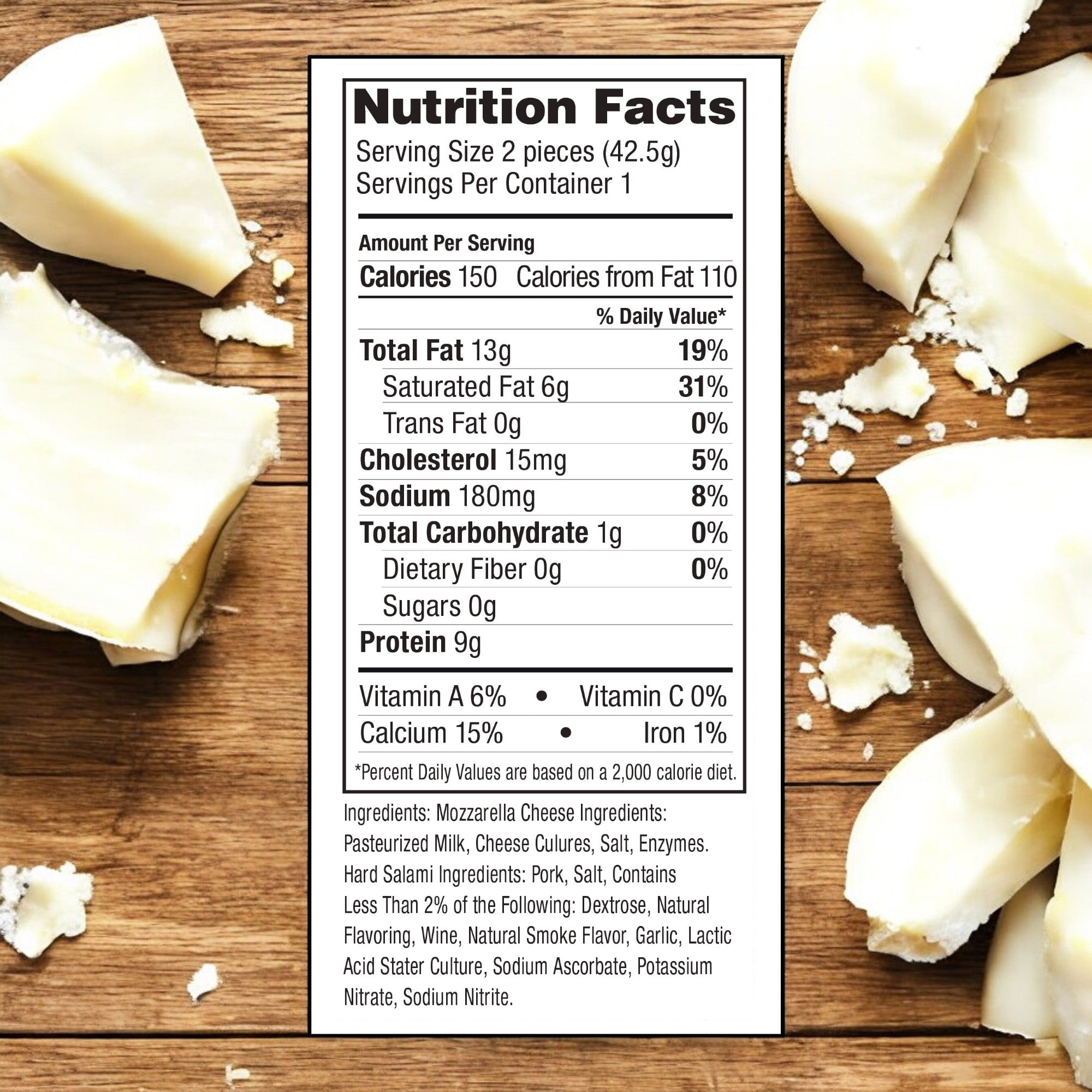 A nutrition facts label for Fiorucci Hard Salami and Mozzarella Cheese Panino on a wooden surface, showing details like 150 calories per serving and 19% daily value of total fat. Perfect as a savory snack, pieces of cheese are scattered around the label, emphasizing its grab-and-go size convenience.