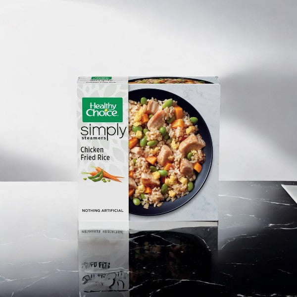 A Healthy Choice Simply Steamers Chicken Fried Rice, 10 oz. - 1 Count package rests on a black marble surface, featuring an image of the nutritious meal on the front.