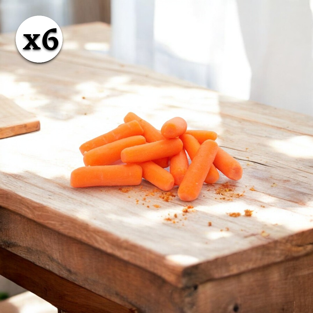 A collection of Imperial Fresh Carrots Baby Cut Peeled, 6 Count (1.6 oz. each), is arranged on a wooden table, illuminated by sunlight with a "x6" graphic in the top left corner—an enticing and nutritious snack option.