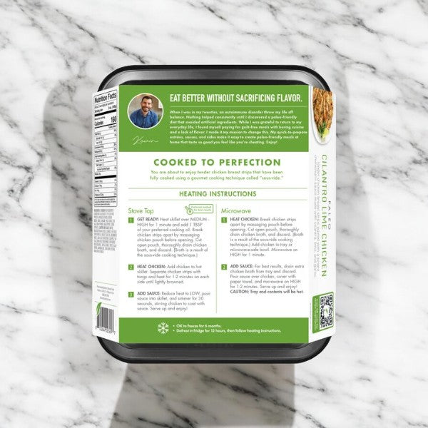 A package of Kevin's Cilantro Lime Chicken rests on a marble surface. The label features an image of a person, heating instructions for both stovetop and microwave, and a green panel with cooking tips. This pre-cooked meal comes in a 16 oz box labeled "Kevin's Cilantro Lime Chicken.