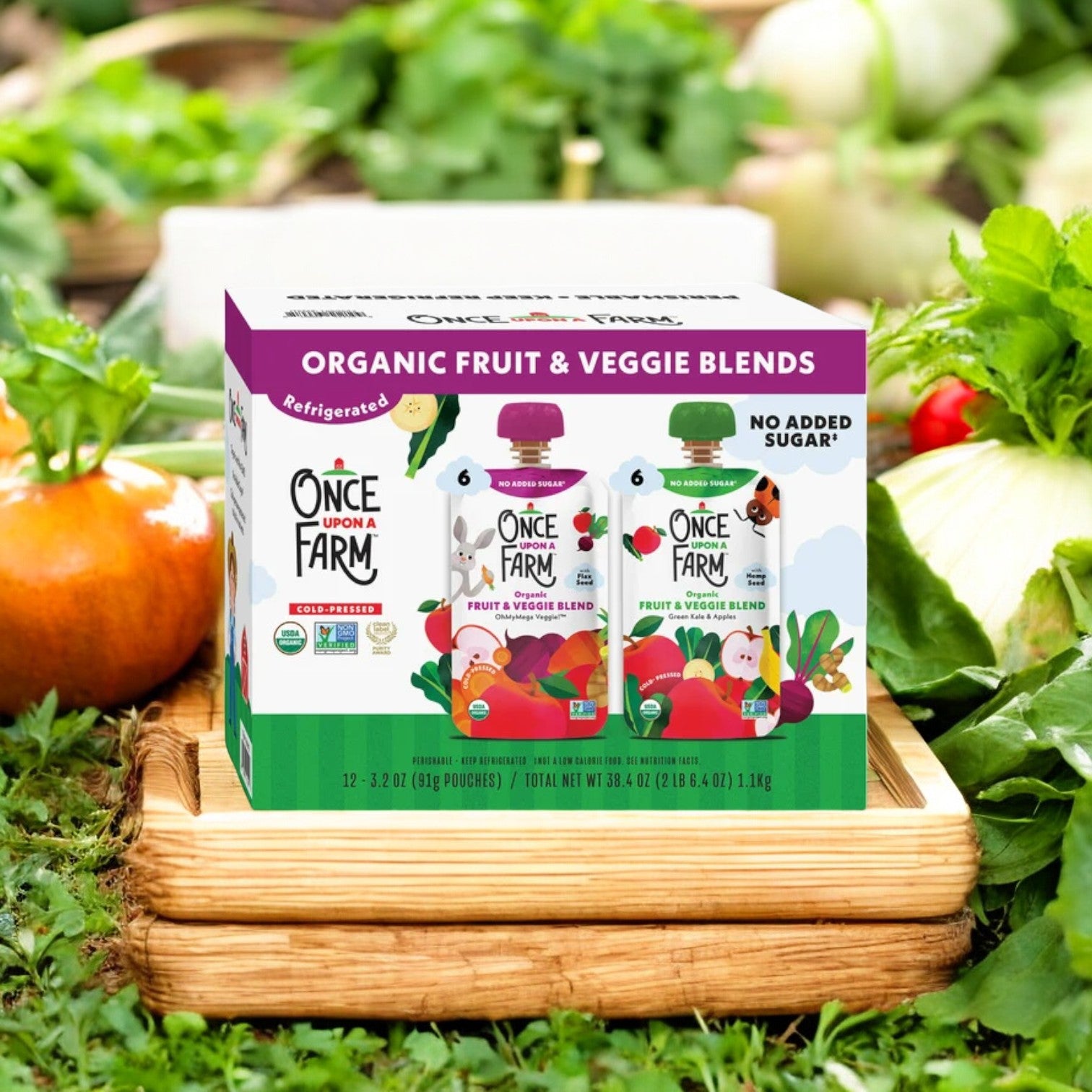 Displayed outdoors, a case of "Once Upon a Farm Organic Fruit & Veggie Blend Variety Pack" is surrounded by an array of fresh produce, featuring the nutrient-rich ingredients found in this vegan and gluten-free selection. Ideal for those seeking natural options, this case includes 48 packs, with six OhMyMega Veggie pouches and six Green Kale and Apples varieties.