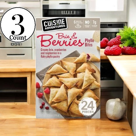 A package of Cuisine Adventure Berries & Brie Phyllo Bites - 3 Count is on the kitchen counter, with its phyllo pastry enveloping melted Brie cheese and ripe raspberries.