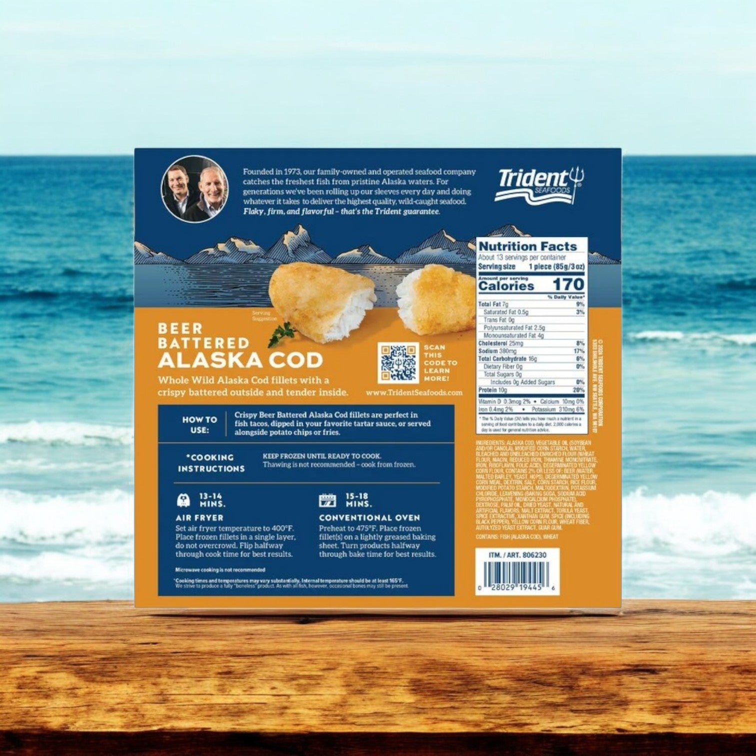 A 7.5 lb box of Trident Seafoods Wild Alaskan Beer Battered Cod sits on a wooden surface by the ocean, featuring cooking instructions and nutritional info. Enjoy sustainably sourced Alaskan flavor in every crispy bite.