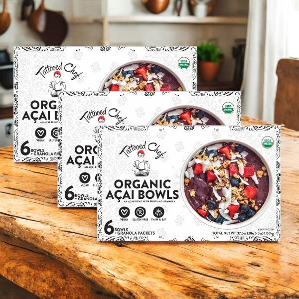 Three cases of Tattooed Chef Organic Acai Bowls (6-count each) are displayed, featuring the vegan ingredients and vibrant acai bowl contents visible through a round window on the Tattooed Chef packaging.