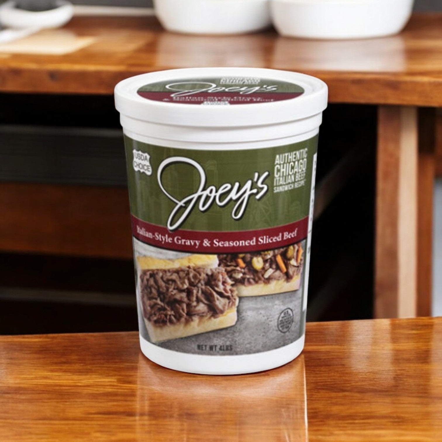 A 4 lb container of Easy Lunches Joey’s Sliced Beef, Gravy & Seasoned, Italian-Style rests on a wooden table, infused with rich Italian spices.