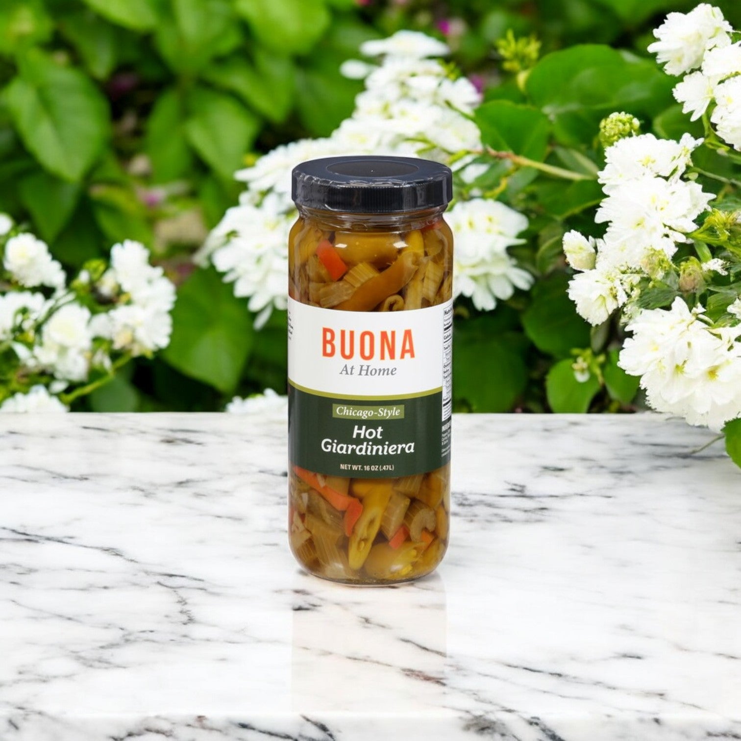 A Buona Marinara Sauce & Meatballs Kit + Italian Beef sits on a marble surface surrounded by flowers and greenery—ideal for adding a spicy kick to your Italian beef sandwich.