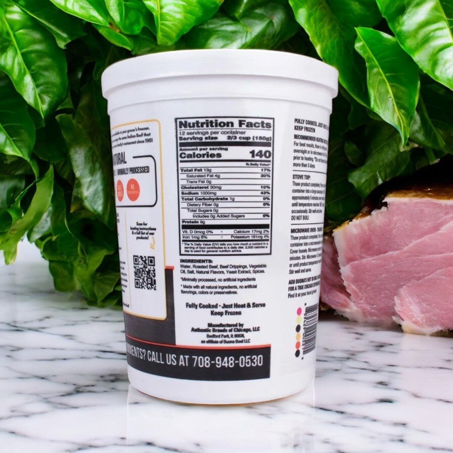 The Buona Italian Style Gravy and Sliced Beef, 68 oz,-3ct on a marble surface surrounded by fresh basil and ham embodies the essence of Italian Beef Sandwiches, highlighting vibrant ingredients perfect for Chicago street food.