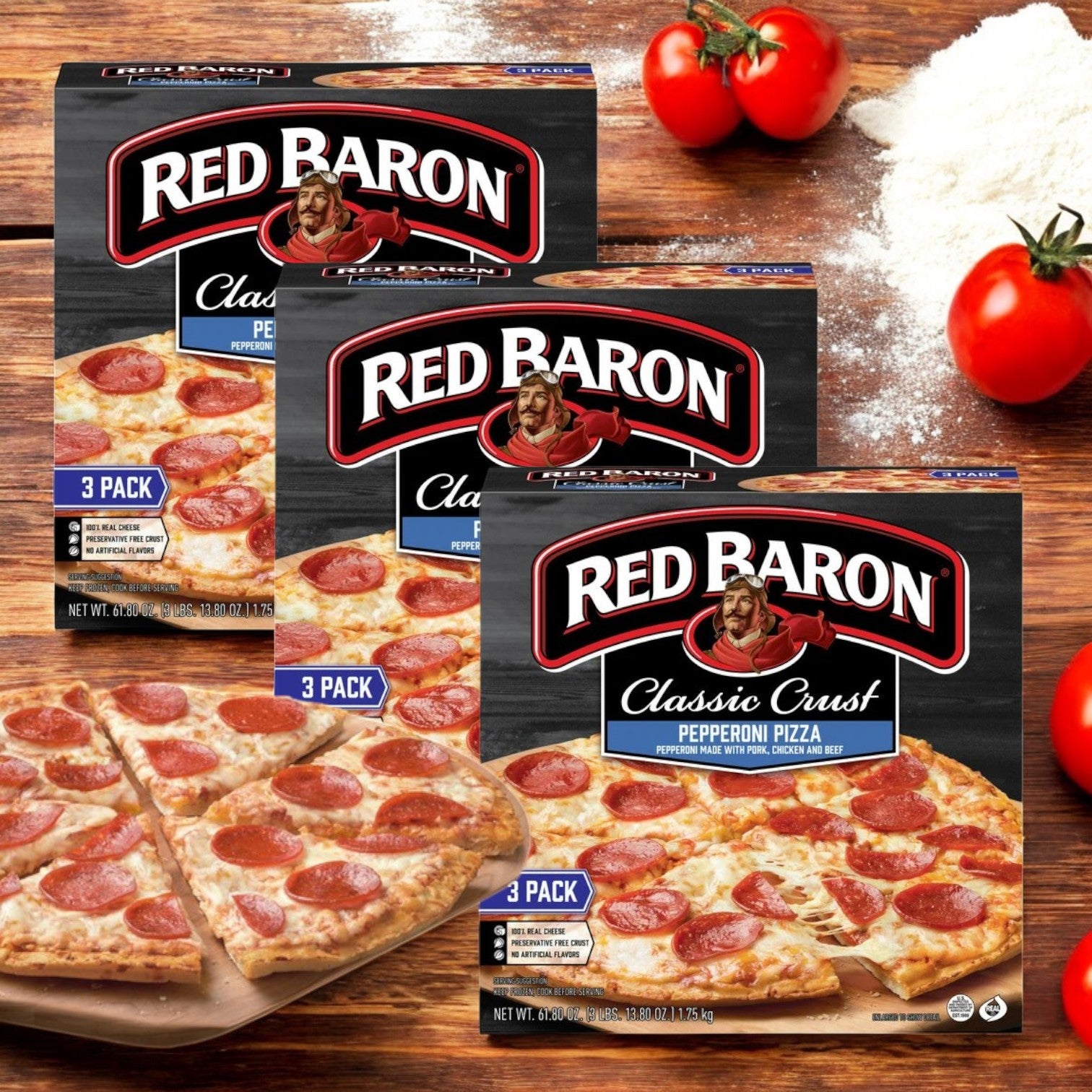 Three boxes of Red Baron Pepperoni Classic Crust Frozen Pizza, with baked pizzas and ripe tomatoes displayed in the background.