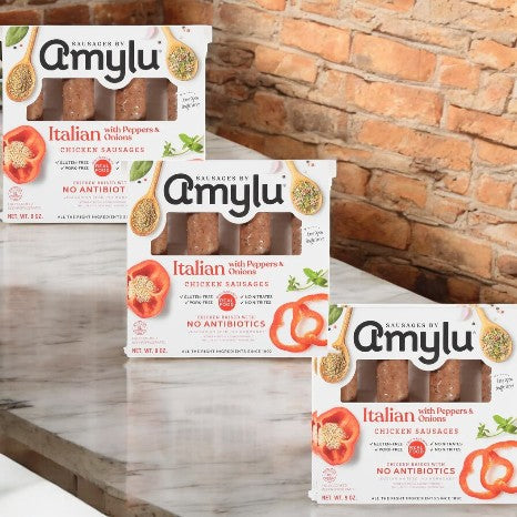 Amylu Italian Chicken Sausage With Peppers & Onions - 3 Count, made with high-quality ingredients, is displayed against a brick background.