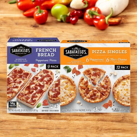 Two boxes of Easy Lunches' Sabatasso's Pizza Bundle on a wooden surface. One box displays 9 French Bread Pepperoni Pizzas, while the other shows a 12-pack containing 6 Four-Cheese and 6 Pepperoni pizzas. Vegetables in the background.