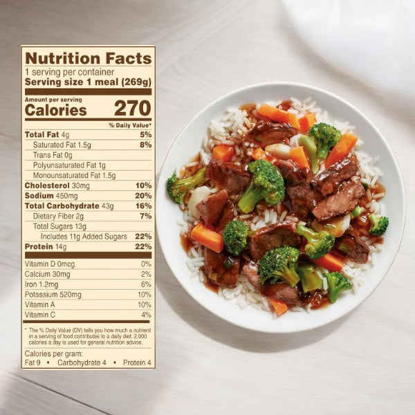 A plate of beef and vegetable stir-fry over white rice sits next to a detailed nutrition facts label showing 270 calories per serving, making it an ideal choice for college dorm room meals. This nutritious meal option truly shines in the Easy Lunches College Ultimate Meal Pack, which includes a variety of meals like Tyson White Meat, Chicken Pot Pies, Taquitos, Sweet & Sour Chicken, Beef Merlot, Beef Teriyaki, and Grilled Chicken Marinara with Parmesan—a total of 55 items!