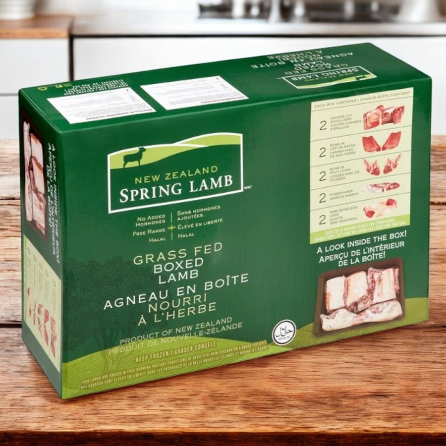 A green box of New Zealand Spring Lamb’s Halal Lamb Carcass (8-Way Cut, avg 28 lb) sits on a wooden surface, showing product info and lamb cuts on the packaging.