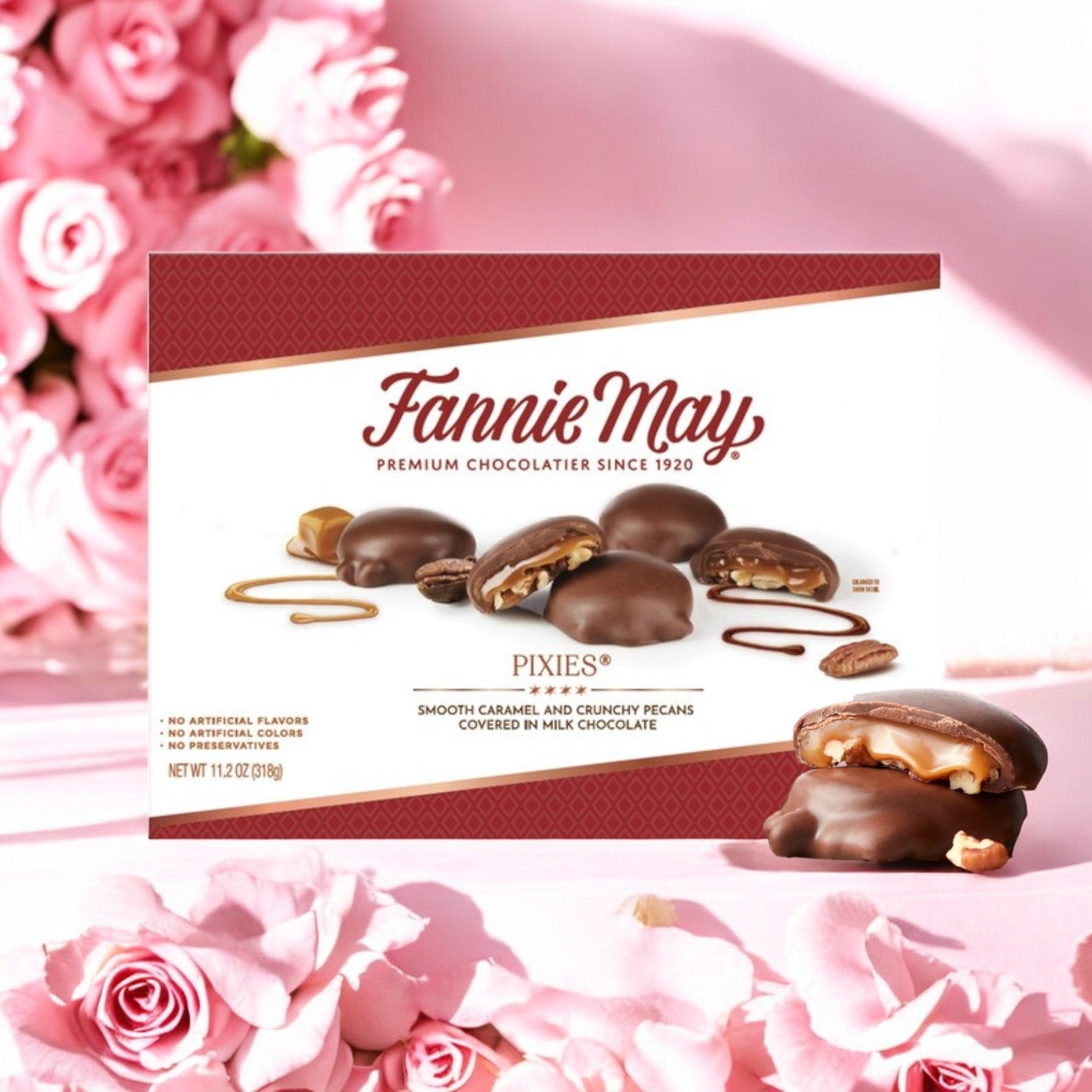 A box of Fannie May Pixies chocolates offers rich milk chocolate filled with buttery caramel and pecans, decorated with pink roses.