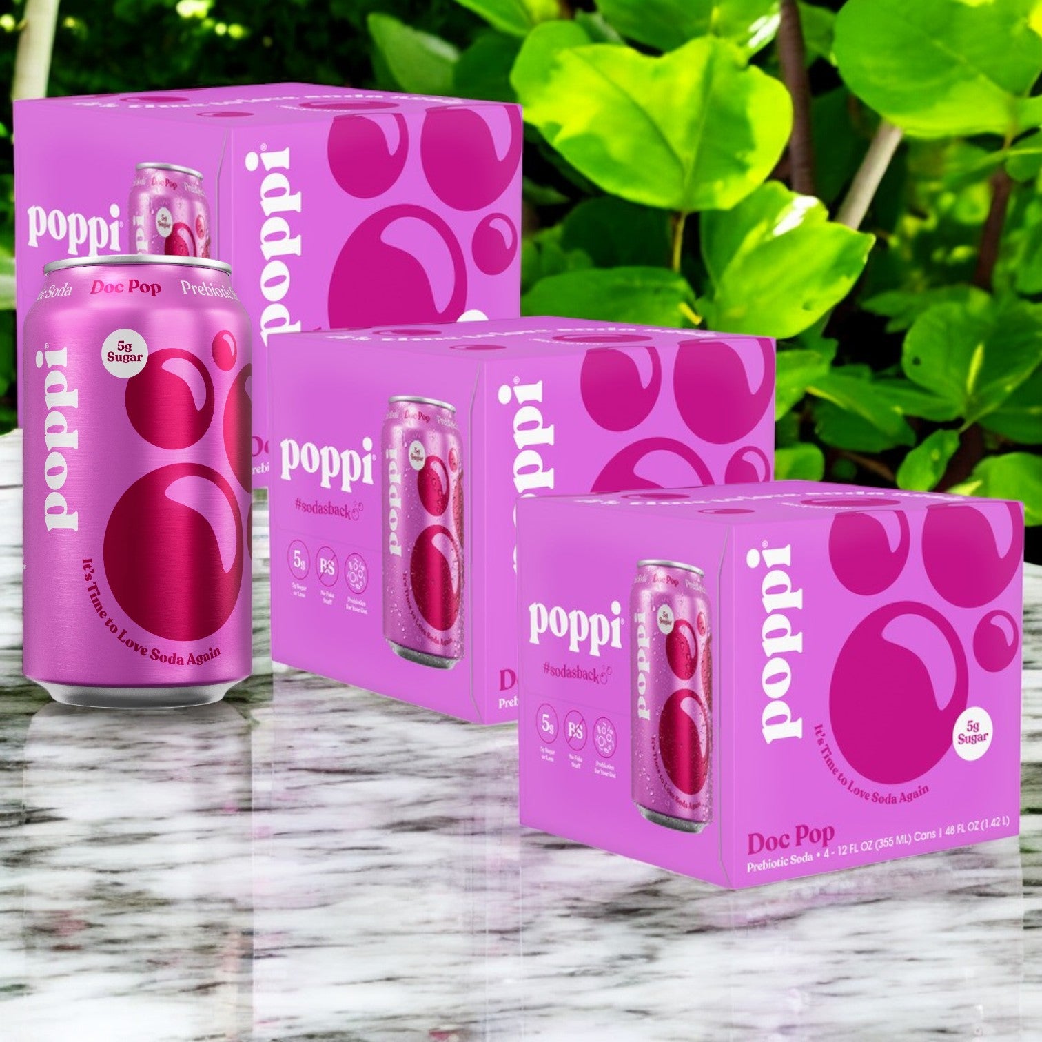 The 12-pack of Poppi Prebiotic Soda in Doc Pop flavor, each can 12 fl oz, is showcased on marble with green foliage. This refreshing soda from Poppi supports digestive health with every sip.