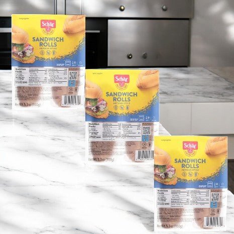 Schar's Artisan Style Gluten-Free Sandwich Rolls (3 count) are elegantly displayed on a marble countertop, highlighting their craftsmanship in a cozy kitchen setting.