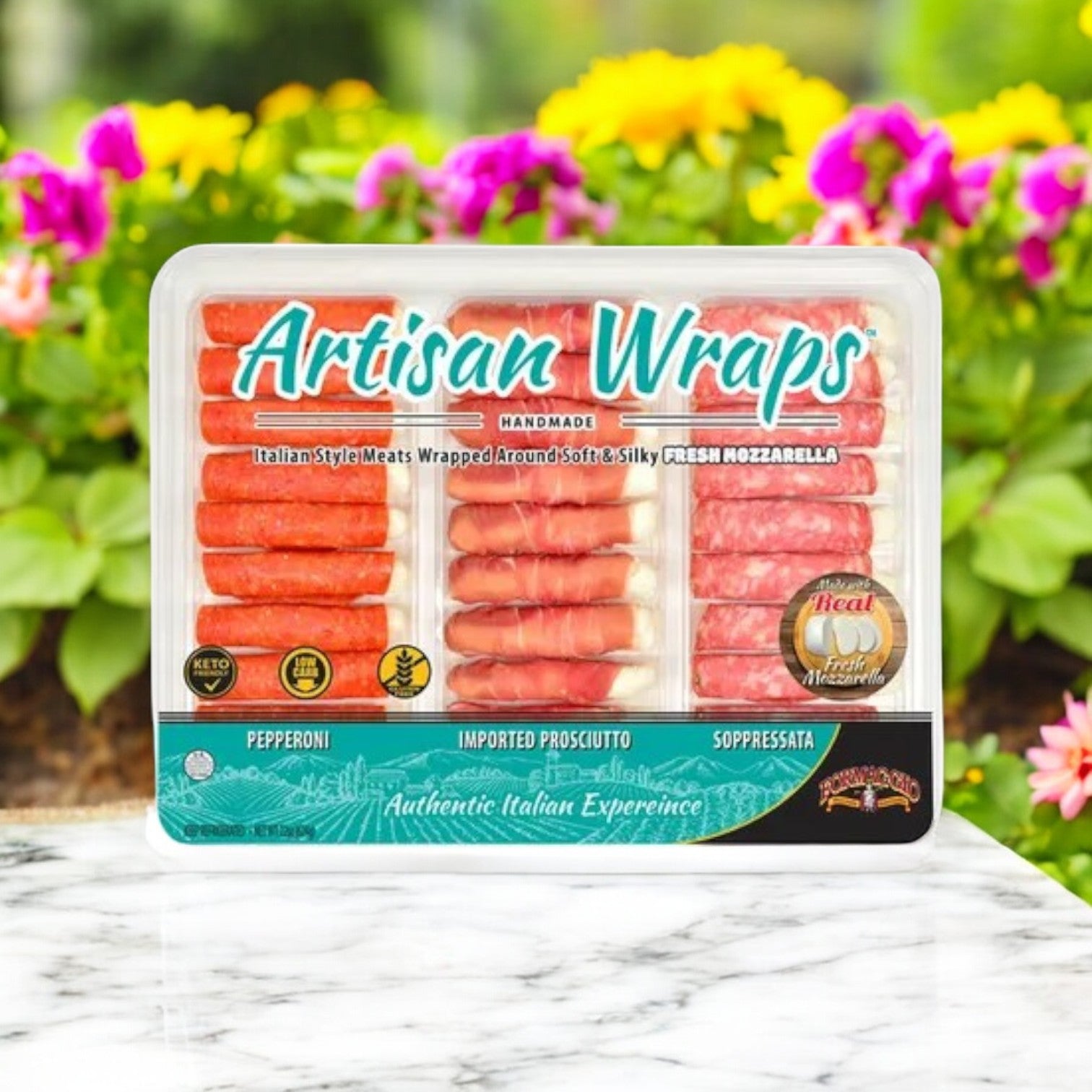 A package of Formaggio Artisan Wraps, 22 oz. - 3 Count by Easy Lunches is elegantly placed on marble with pastel flowers, creating the perfect gourmet snack.