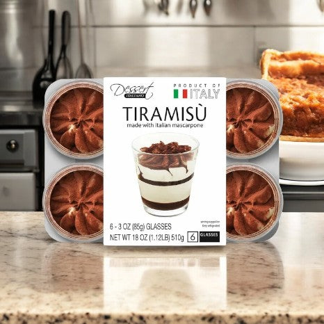 A package of six Tiramisu - Italiano Tiramisu Cups from Kirkland Signature sits on the kitchen counter, each filled with rich mascarpone cream. The label reads "Product of Italy" and "Tiramisu made with Italian mascarpone," showcasing this classic Italian dessert.