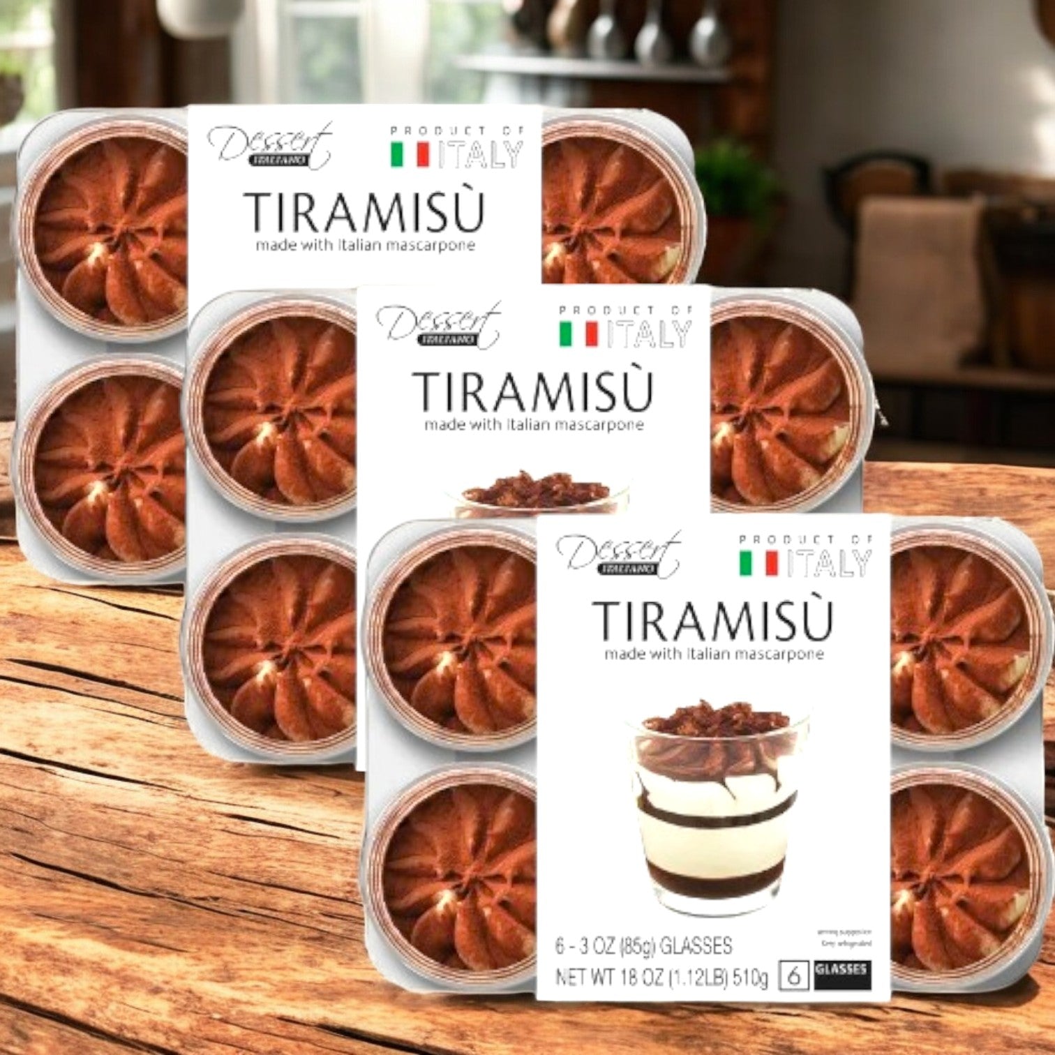 Three boxes of Kirkland Signature Tiramisu - Italiano Tiramisu Cups are displayed on a wooden table, each cup featuring creamy mascarpone and labeled "Product of Italy"—a classic Italian dessert.
