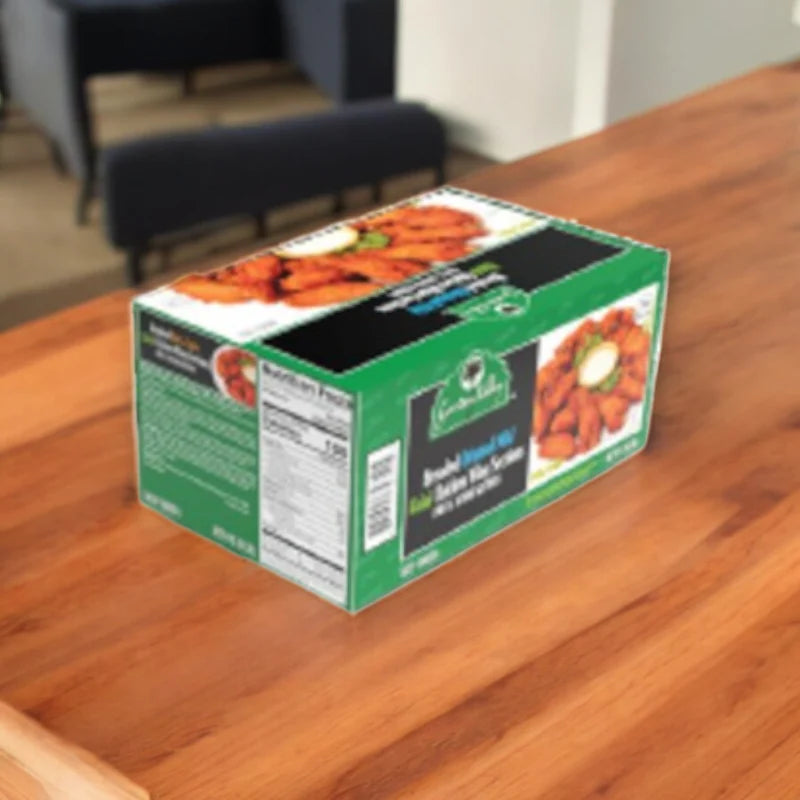 A green and black box labeled "Buffalo Style Wings" sits on a wooden table indoors, next to Thomas Farms 3-Pack Halal Meat Bundle.