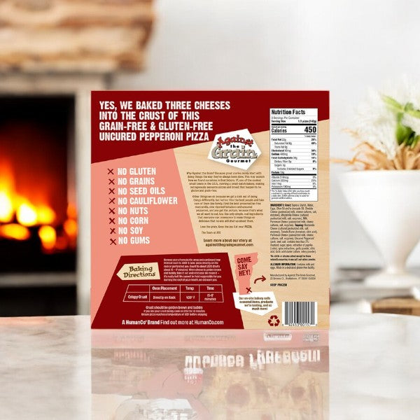 A box of Against The Grain Gluten & Grain Free Uncured Pepperoni Pizza by Easy Lunches, labeled as Sharing Size and weighing 15 oz - 1 Count, is shown on a kitchen counter, featuring nutritional information and ingredient details.