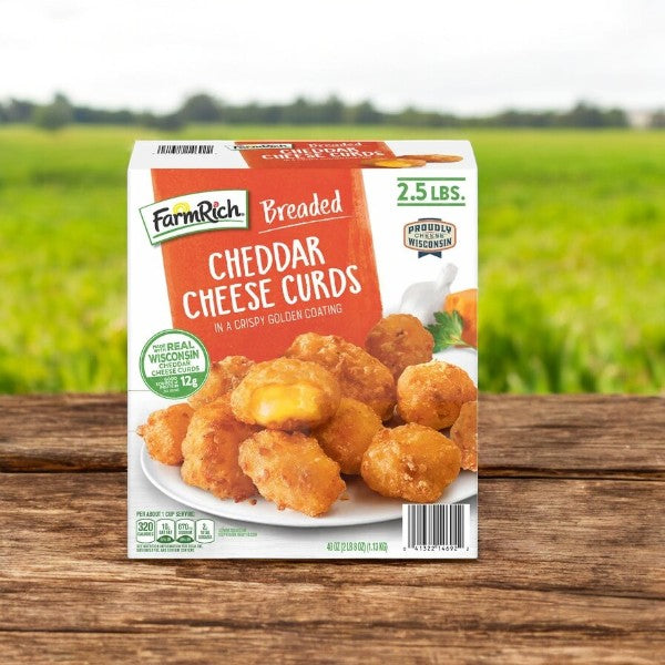 Farm Rich Breaded Cheddar Cheese Curds, 2.5 lbs-1 Count, displayed on a wooden surface with enticing packaging featuring delicious imagery and label details—ideal for snacking or as an appetizer in an inviting outdoor setting.