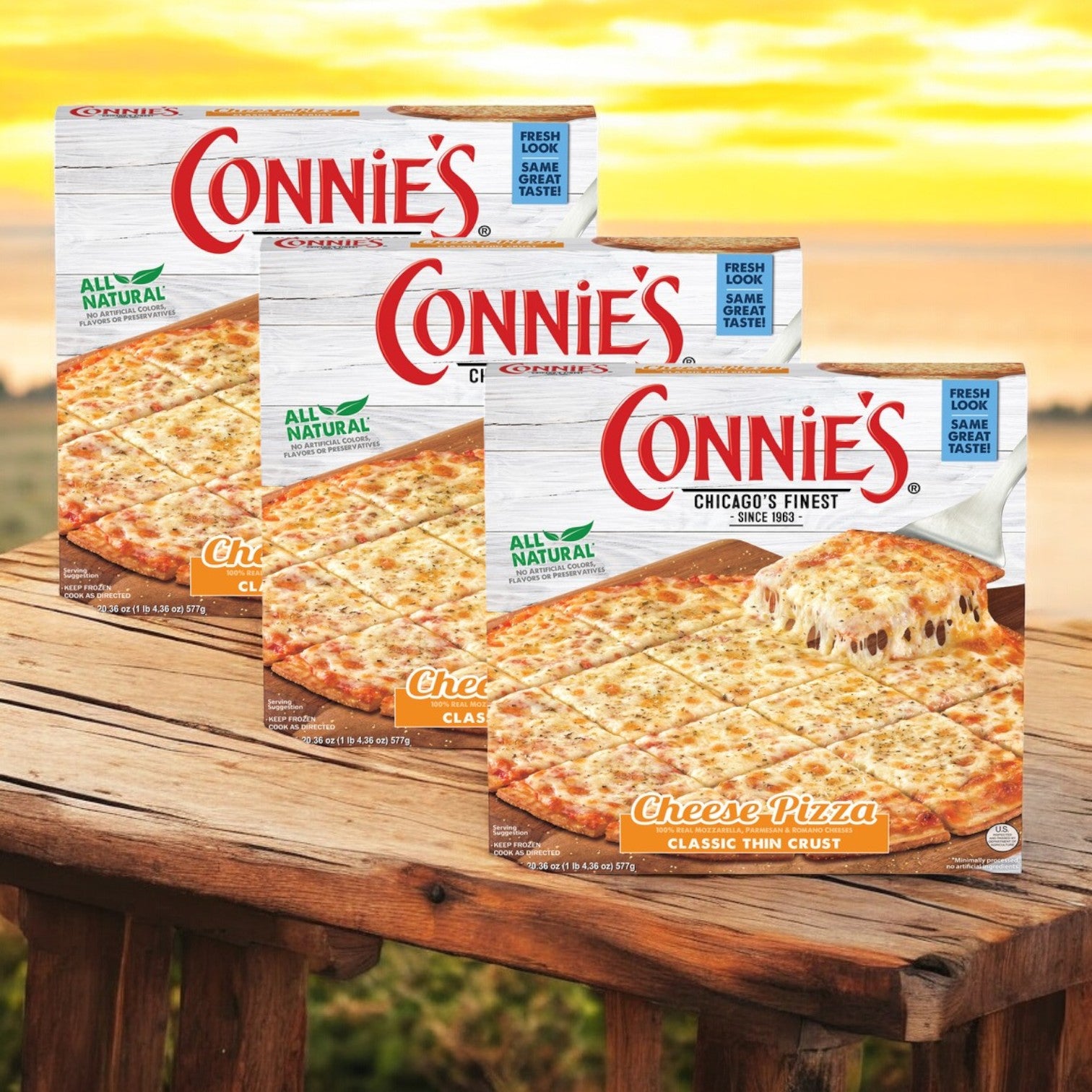 Boxes of Connie's Pizza Classic Thin Crust Cheese, a delicious product from Connie's Pizza, lay on a wooden table against an outdoor backdrop. Ideal for those who savor classic thin crust pizzas, each 20.36 oz pizza is ready to bake and enjoy in no time.