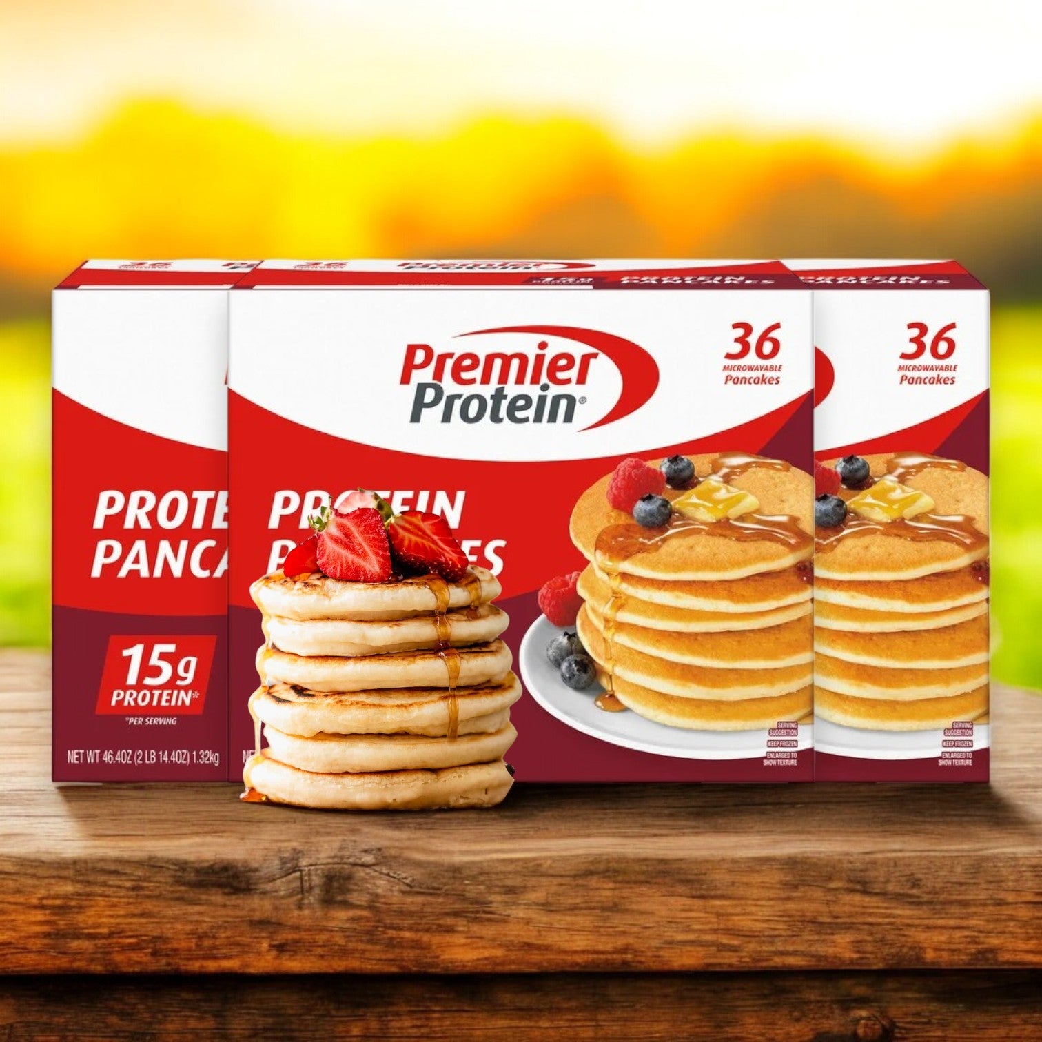 Premier Protein Pancakes come in 36-count packs and are displayed outdoors on wood, featuring images of berry- and syrup-topped pancakes on their packaging.