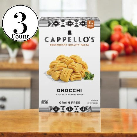 A package of Cappello's Gnocchi Pasta- 3 Count is placed on a wooden kitchen counter, encircled by fresh vegetables. This paleo-friendly offering from Cappello's provides a delightful grain-free choice for fans of gluten-free gnocchi treats.