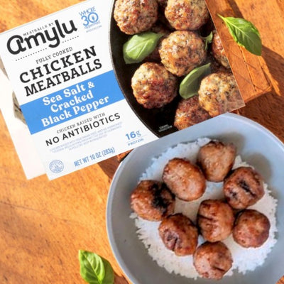 Savor Amylu's delightful chicken meatballs made from premium chicken, fully cooked with sea salt and cracked black pepper. These gluten-free bites are perfect over rice, topped with fresh basil for a tasty meal.