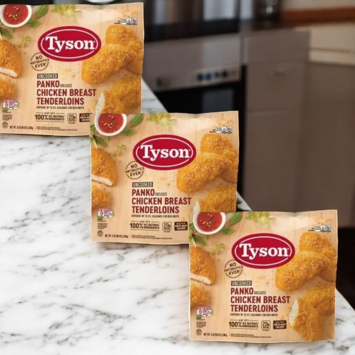 Three packages of Tyson Panko Breaded Chicken Breast Tenderloins, 5 lbs each, are displayed on a marble countertop.