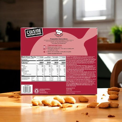 A box of Cuisine Adventures Puff Pastry Bites Variety Pack - 1 Count from Cuisine Adventure rests on a wooden table in a sunlit kitchen, surrounded by tempting gourmet cuisine and other delicious morsels, complete with nutritional facts.