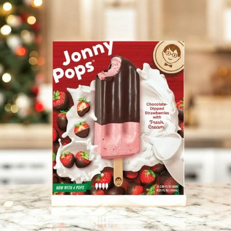 Box of Kirkland Signature's JonnyPops Chocolate Dipped Cherries With Fresh Cream-1 Count, featuring a chocolate-dipped cherry ice cream bar with fresh cream. Background is blurred with holiday decor.