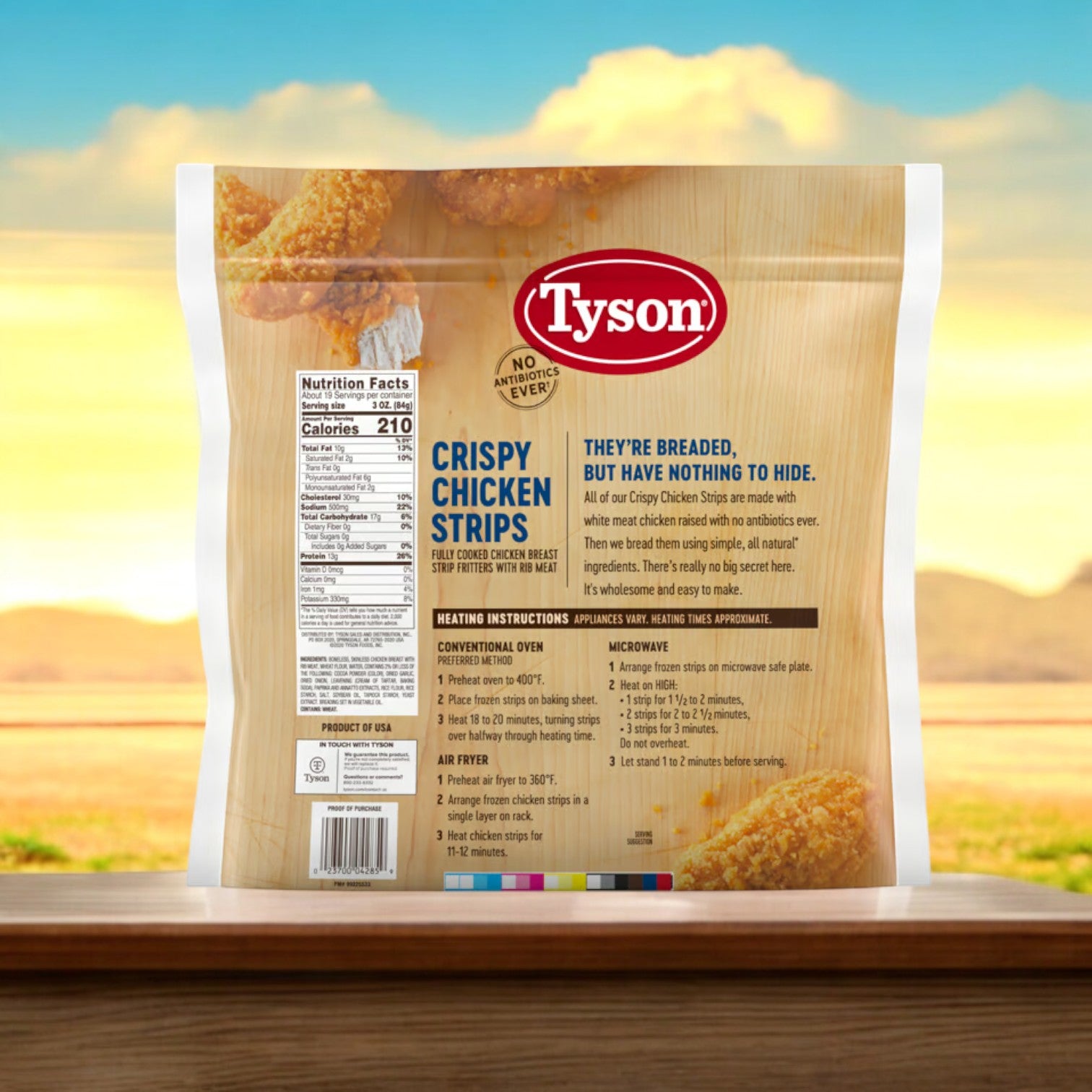 A package of Tyson Fully Cooked Crispy Chicken Strips, 3.5 lbs. - 1 Bag sits on a wooden ledge, providing an easy meal option. The packaging showcases nutritional details and cooking instructions with a blurred outdoor backdrop, emphasizing the perfectly cooked quality of these strips by Tyson.