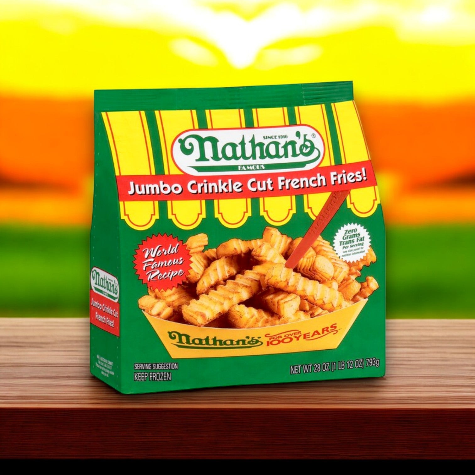 A 28 oz bag of Nathan's Famous French Fries, Crinkle Cut, Jumbo rests on a wooden surface with a blurred sunset backdrop, highlighting their world-famous recipe.