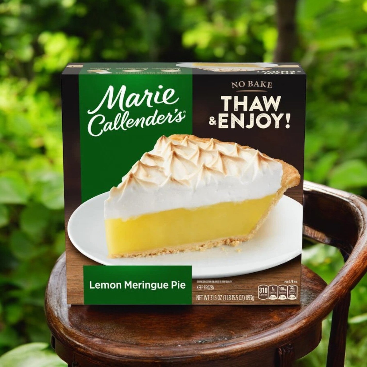 On a wooden surface, a box of Marie Callender's Lemon Meringue Pie Frozen Dessert (31.5 oz, 3 count) sits surrounded by lush greenery, offering a refreshing citrus flavor with every slice.