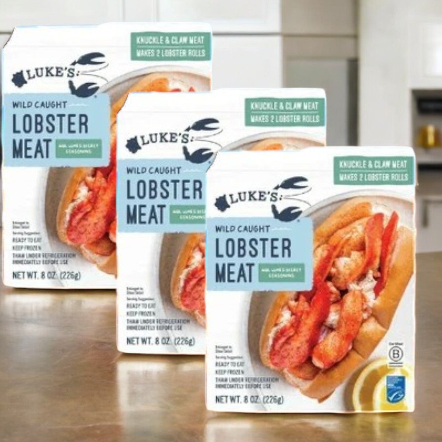 Displayed are three boxes of Luke's Lobster Wild-Caught Lobster Meat, each 8 oz box including knuckle and claw meat seasoned with Luke's Secret Seasoning. This sustainably sourced product offers lobster rolls garnished with lemon slices for a deliciously fresh taste.