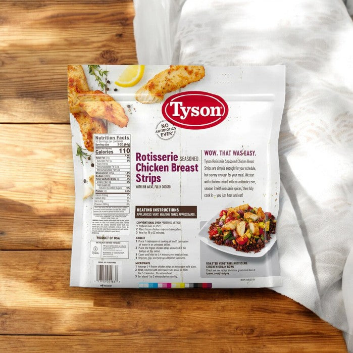 A bag of Tyson Rotisserie Seasoned Unbreaded Chicken Breast Strips rests on a wooden surface next to a white cloth. The packaging highlights nutritional facts, heating instructions, and a serving suggestion image.