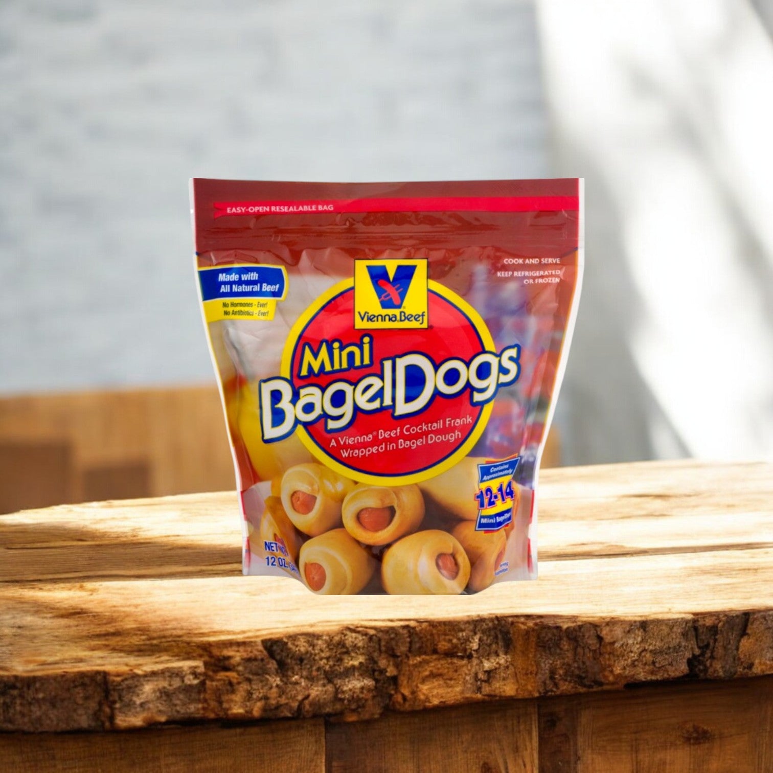 A Vienna Beef Mini Bagel Dogs package from Easy Lunches lies on a wooden surface, vibrant red with images of bagel dogs and text indicating 12 to 14 pieces. Ideal for a Chicago Feast, pair with Giordano's Deep Dish Pizzas! Perfect for Parties! Enjoy free shipping!.