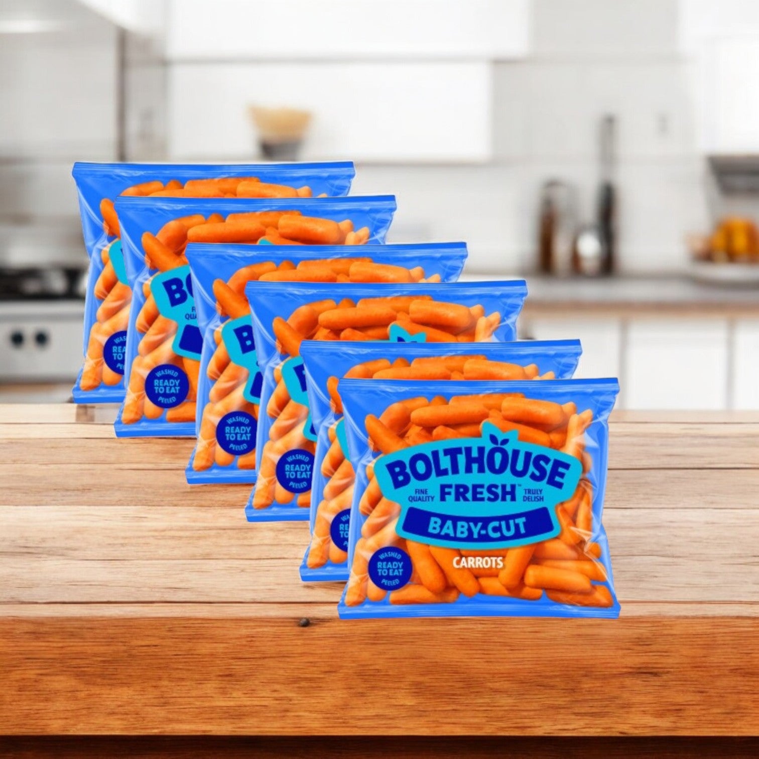 Five bags of Bolthouse Farms Carrots Baby Cut Peeled, 1.6 oz. - 6 Count are neatly arranged on a wooden counter, highlighting a healthy snack rich in dietary fiber.