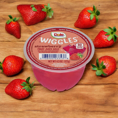 A 4.3 oz Dole Wiggles Strawberry Fruit Juice Gel cup sits on a wooden surface, surrounded by whole strawberries, offering a delicious and fun way to enjoy the benefits of Vitamin C.