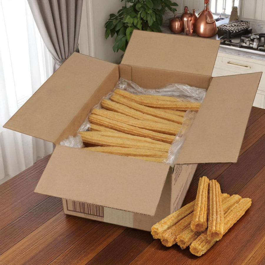 A case of Hola Churro® Pre-Fried Plain Churros (100 ct, 10") from Hola Churro is displayed on a kitchen table, with several churros arranged outside the open box for display.