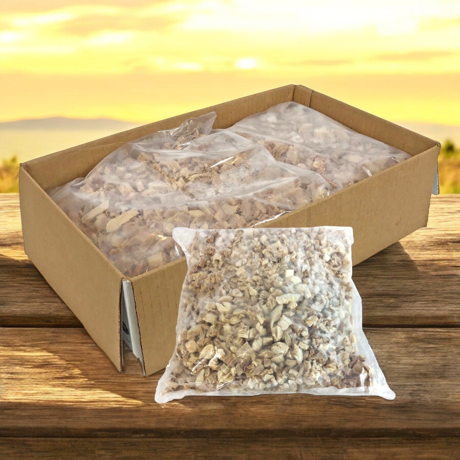 A box of sealed plastic bags filled with dried mushrooms rests on a wooden table beside Sysco Classic Diced Chicken Meat, 0.5 Inch Dark & White – 2/5 LB, with an artfully blurred outdoor background.