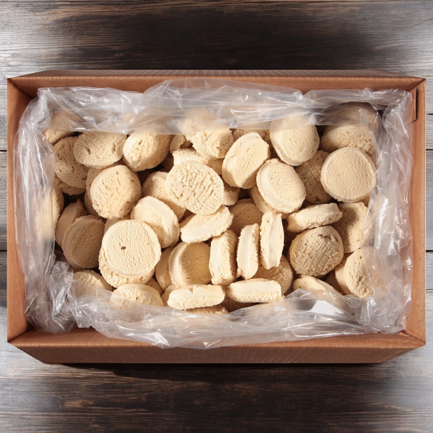 A case containing 160 pieces of Otis Spunkmeyer Dough Cookie Butter Sugar in a plastic liner, placed on a wooden surface.