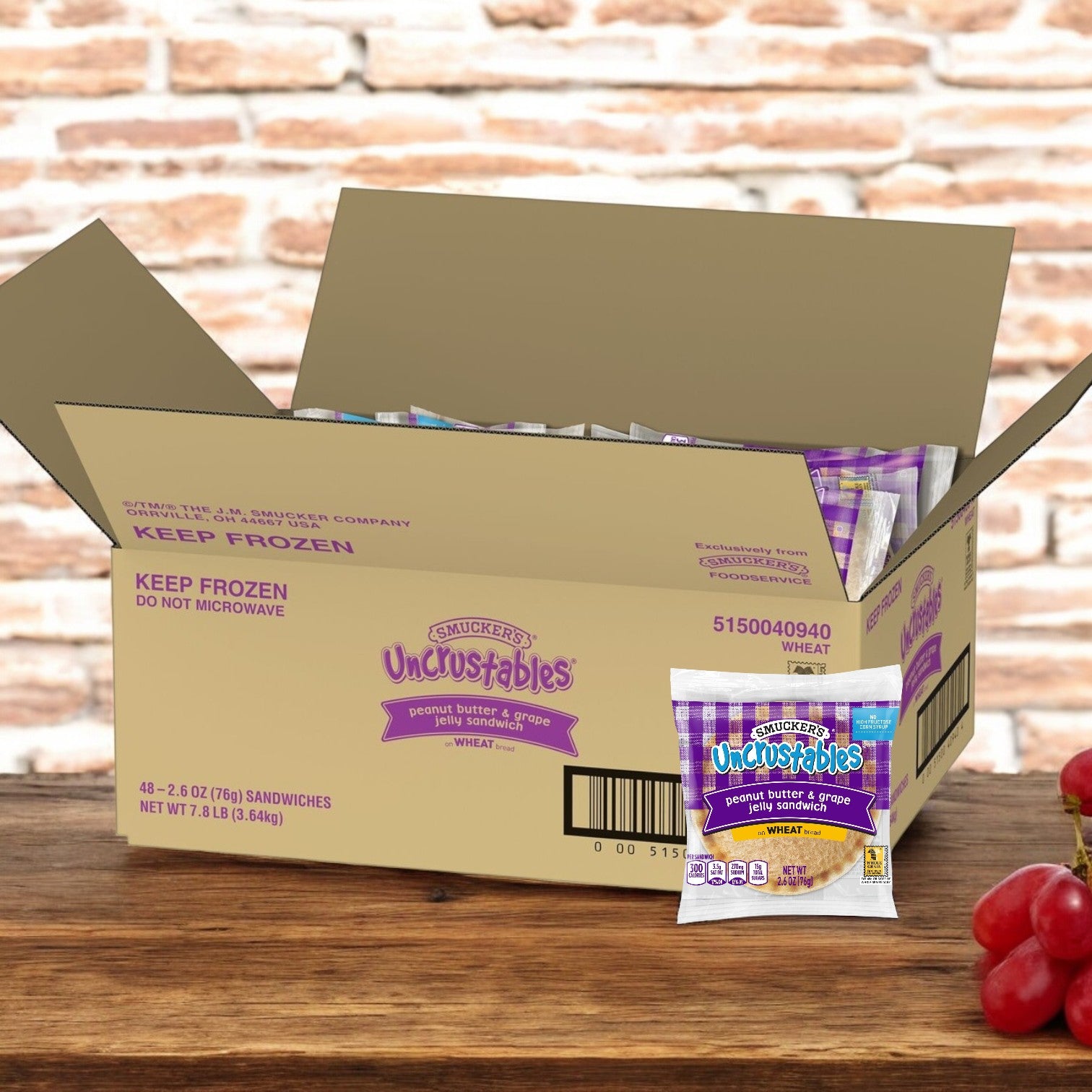 A box of Uncrustable Smuckers Peanut Butter & Grape Jelly Wheat Sandwiches, 2.6 oz each, with one sandwich displayed in front, contains 48 sandwiches.