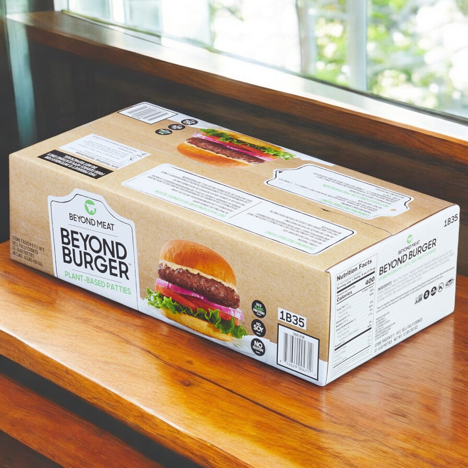 A box of Burger Vegetarian Beyond Patty, 32 Pack from Beyond Meat sits on a wooden surface, displaying its nutritional information on the packaging—an ideal plant-based choice for those looking for delicious meat-free options.