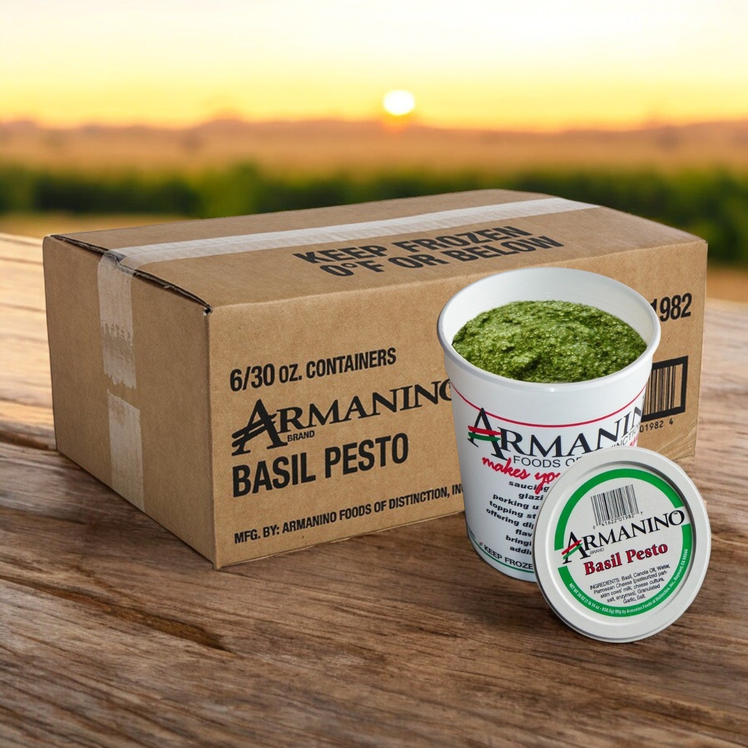 An open tub of Armanino Pesto Sauce sits beside a sealed one in front of a box labeled "6/30 oz Packs." The scene, set against a blurred outdoor backdrop, evokes an authentically Italian and delightfully gluten-free flavor experience.