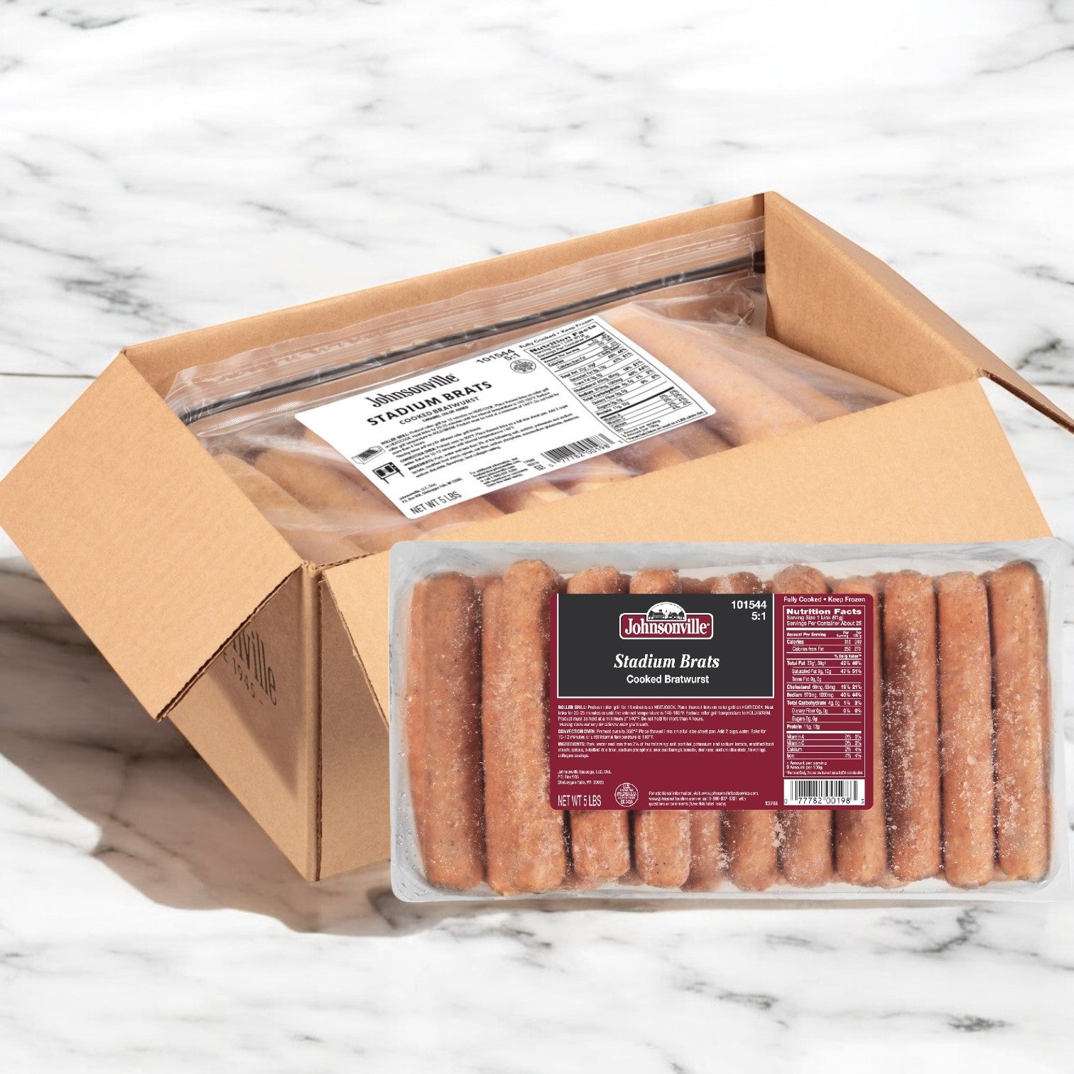 A cardboard box on a marble surface contains multiple packs of Johnsonville Foods Bratwurst, each offering savory, pre-cooked 5.5" delights with 5 bratwursts per pack.