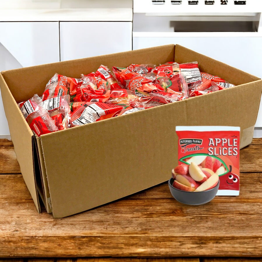 A large cardboard box labeled "Fresh Sliced Apple Packs for Convenient Snacking, 2 oz. -1 Cases- Bulk 100" by Peterson Farms sits on a wooden surface. One package shows apple slices in a bowl, promoting these healthy snacks.